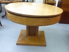 A 1930s Jupe patent oak extending dining table, on a pedestal base  30"h  47"dia