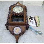 A late 19thC mahogany and walnut veneered wall clock; the 8 day movement faced by a Roman dial  36"h