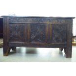 An 18thC tri-panelled and carved oak chest with a hinged lid, raised on cut-out legs  26"h  45"w