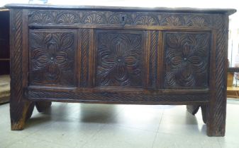 An 18thC tri-panelled and carved oak chest with a hinged lid, raised on cut-out legs  26"h  45"w