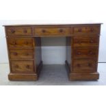 A mid Victorian mahogany nine drawer, twin pedestal desk, on a plinth and casters  30"h  48"w