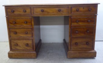 A mid Victorian mahogany nine drawer, twin pedestal desk, on a plinth and casters  30"h  48"w