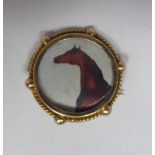 A 9ct gold picture brooch of circular form with a picture of a horse
