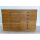 A mid 20thC fruitwood collector's chest with two banks of six drawers, some with dividers, on a