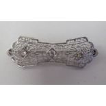 A white gold coloured metal, diamond set and filigree style brooch