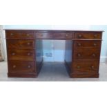 A late Victorian mahogany partner's desk, the top set with a tooled green hide scriber, raised on