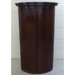 A late 19thC mahogany two door quadrant corner hanging cabinet  44"h  25"w  17"deep