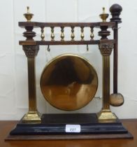 A late Victorian brass and hardwood table gong, suspended between two square pillars  14"h with an