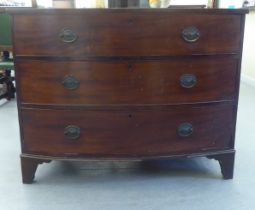 A 19thC mahogany three drawer bow front dressing chest with brass bail handles, raised on bracket
