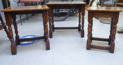 A nesting set of three Titchmarsh & Goodwin oak occasional tables, raised on turned and block