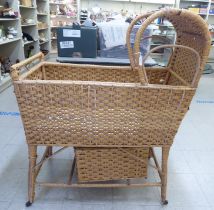 A Welsh woven cane crib with an integrated canopy and stand, on casters; and a storage box  31"L