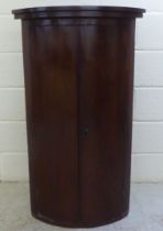 A late 19thC mahogany two door quadrant corner hanging cabinet  44"h  25"w  17"deep