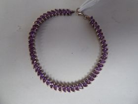 A silver oval link bracelet, set with marquise cut amethysts