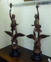 A pair of late Victorian spelter table lamps, each fashioned as a figure, standing over an eagle