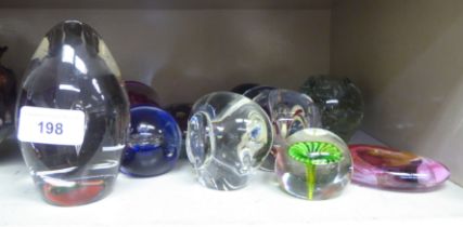 Thirteen coloured glass paperweights: to include an ocean spray; and another of elephant design