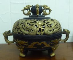A 20thC Oriental bronze and parcel gilt censer with opposing twin handles and cover, having