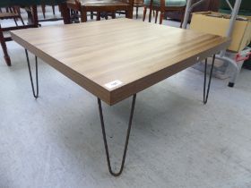 A modern 1970s design coffee table with a laminated teak/hardwood effect veneered top, on cast metal