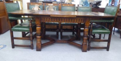 A 20thC Old English style oak draw leaf table, raised on ring turned and block legs, united by a