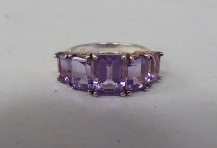 A silver ring, set with five graduated amethysts