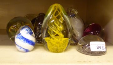 Thirteen coloured glass paperweights: to include one yellow spiraltwist; and another with a multi-