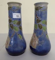 A pair of early 20thC Royal Doulton stoneware vases, decorated in tubeline with flora  bearing