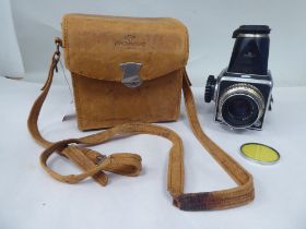 A Hasselblad 1000F camera, in a stitched tan hide case