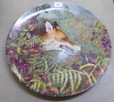 A Continental tin glazed earthenware charger, decorated with a fox in undergrowth  17"dia