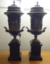 A pair of 18thC French style ceramic black glazed, cylindrical, covered, twin handled urns,