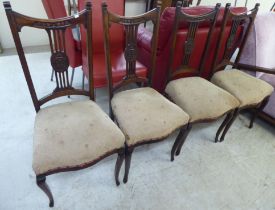 A set of four Edwardian mahogany framed salon chairs, each with a splat back and upholstered seat,
