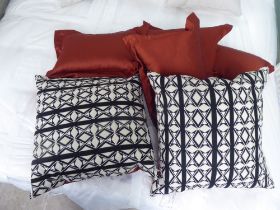 Six scatter cushions with duck feather inserts, two red with black/white on the reverse and four red