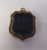 An antique engraved yellow metal, hinged locket, set with a bloodstone