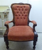 A late Victorian walnut framed salon chair with an orange fabric upholstered back and seat, raised