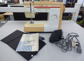 A vintage Jones model VX810, mains electric sewing machine, in a three tone plastic casing with