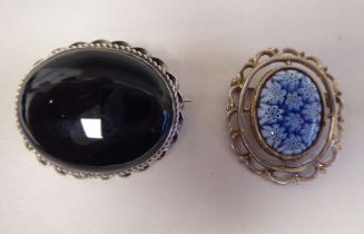 Two silver framed oval brooches
