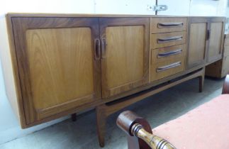 A G-Plan teak sideboard with a central bank of four drawers, flanked by two pairs of cupboard doors,