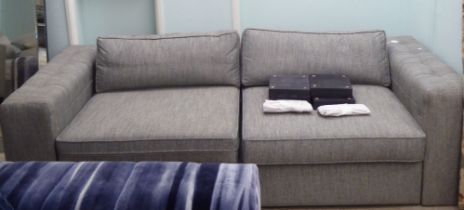 A modern bed settee with a level back and box arms, upholstered in grey flecked fabric with a
