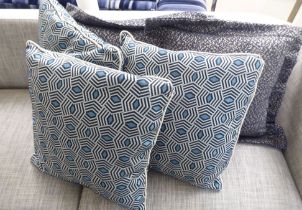 Three geometric pattern blue and cream scatter cushions; and two in black/fawn