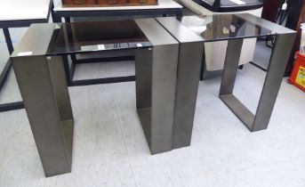 A pair of modern burnished bronze coloured steel framed lamp table with smoked plate glass tops