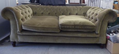 A late Victorian two person Chesterfield style settee, upholstered in green buttoned fabric,