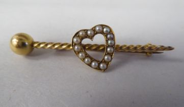 A Victorian yellow metal seed pearl set bar brooch, surmounted by a heart