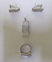 A suite of silver jewellery, set with white stones: to include a ring, a pendant and two earrings