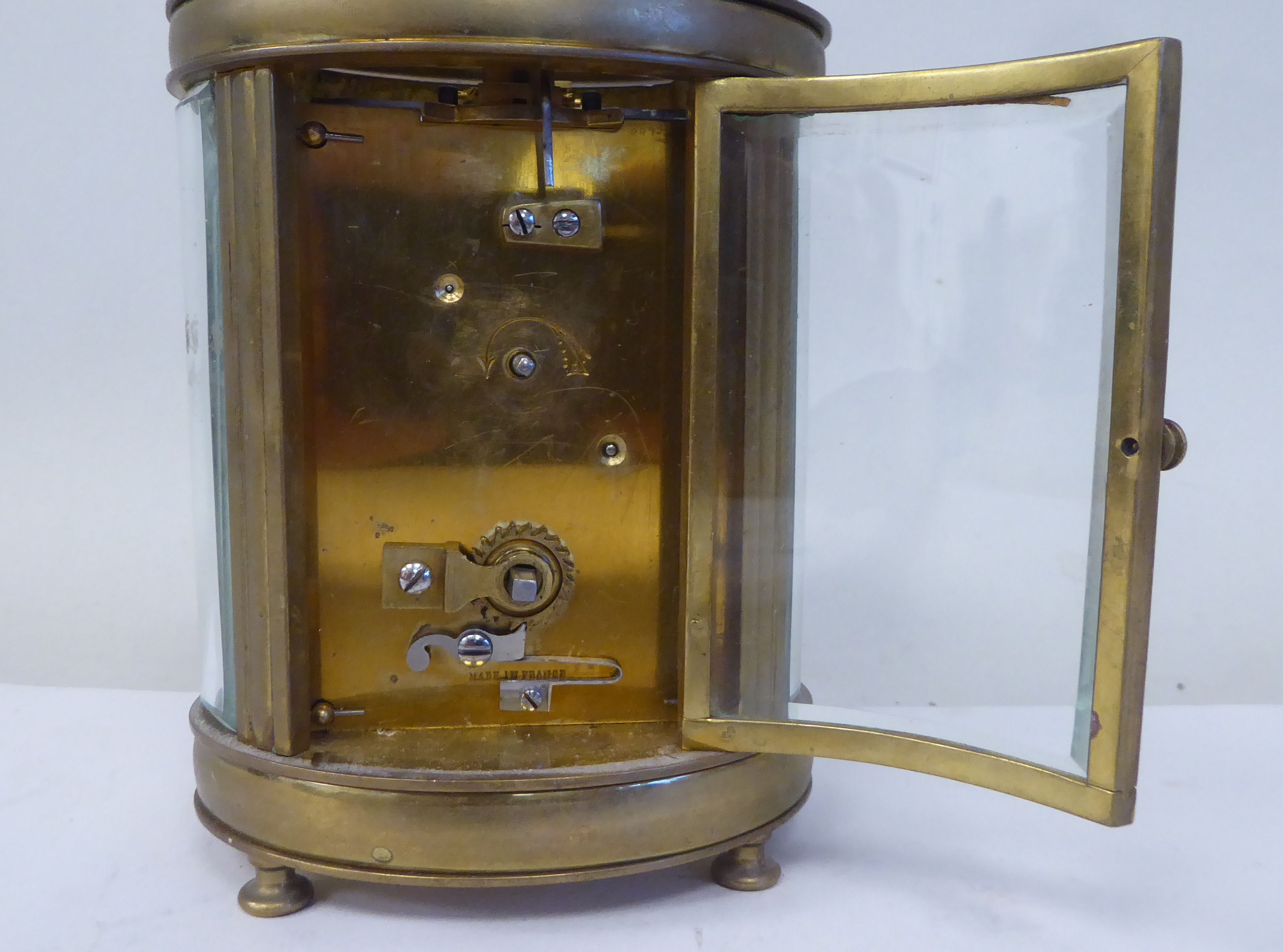 An early 20thC French oval brass cased carriage timepiece with bevelled glass panels and a folding - Image 6 of 11