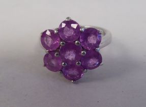 A white metal cluster ring, set with seven pink sapphires  stamped 925