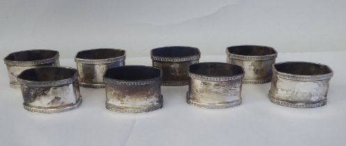 A set of eight silver coloured metal oval napkin rings with egg and dart cast borders  bearing