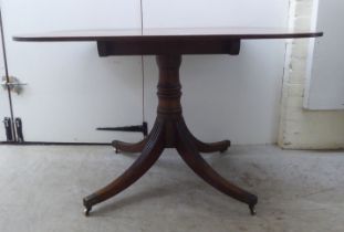 A Regency mahogany single pedestal dining table, raised on splayed sabre legs and casters  28"h