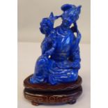 An Oriental carved lapis lazuli kneeling figure, wearing traditional ceremonial costume, holding a