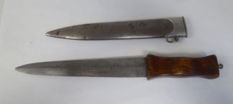 A German dagger with a wooden handgrip, the blade with an engraved motto  9"L in a metal sheath