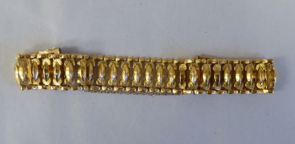 An 18ct gold wide, flexible and engraved, open link bracelet, on a bayonet clasp with safety chain
