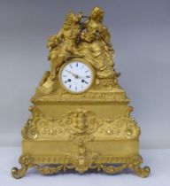 A 19thC French gilt metal cased mantel clock, featuring a seated couple, on a draped cushion, the