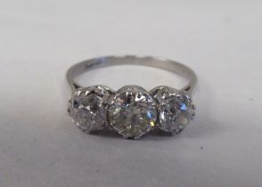A white coloured metal three stone claw set diamond ring